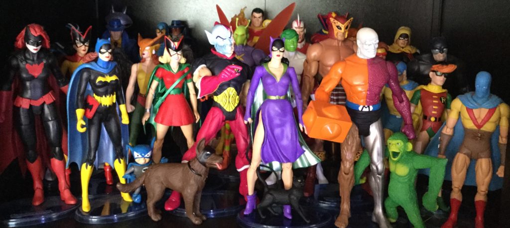 A picture of approximately 25-30 action figures of DC Comics super-hero characters.