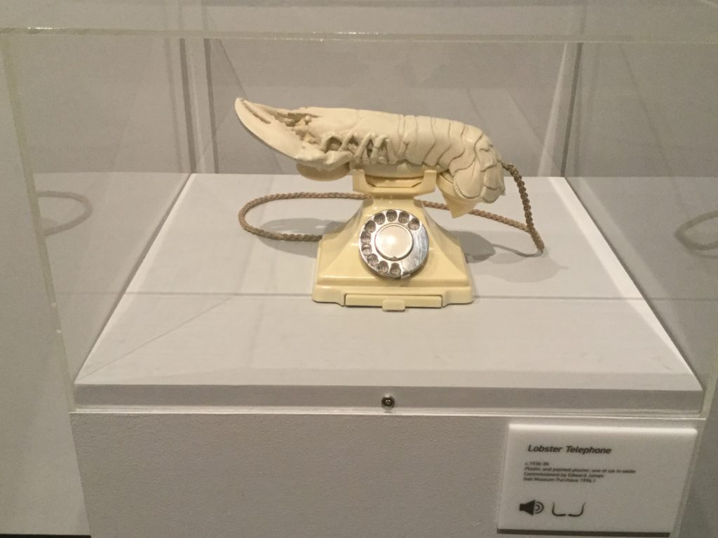 Salvador Dali's "Aphrodesiac Telephone" sculpture, which is a sculpture of an ivory-colored rotary telephone with an ivory-colored lobster replacing the phone receiver. The link directly below this image and its caption goes to the Dali Museum's page on the sculpture, and gives a detailed description of the sculpture and its history.