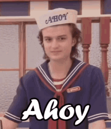 An animated GIF of actor Joe Keery, a young man with white skin and brown hair, portraying character Steve Harrington from the television series "Stranger Things", in his red, white and blue Scoops Ahoy sailor-ish work uniform, saying "Ahoy" on a loop, with the word "Ahoy" written below him in white lettering.
