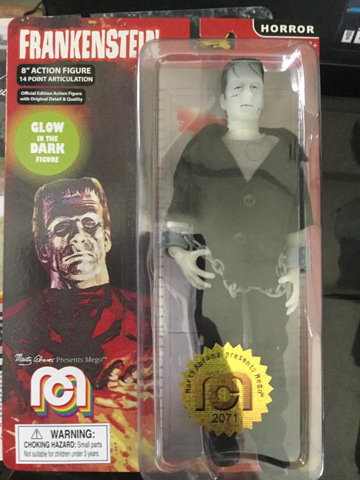 Mego Glow In The Dark Frankenstein action figure in original packaging. Action figure of Mary Shelley's Frankenstein's Monster (a white skinned humanoid with black hair, in a black suit and grey shirt) in shackles, in bubble on red card with painted Frankenstein image.