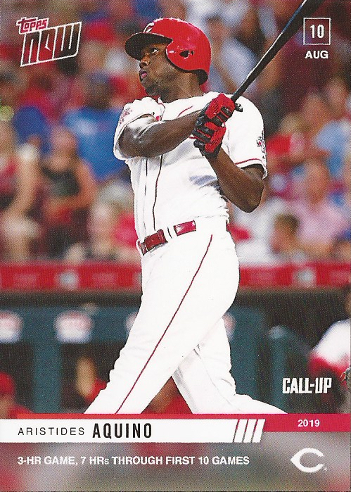 A Topps Now card of Cincinnati Reds outfield Aristides Aquino (pictured; a man with brown skin in a white uniform with red trim, wearing a red batting helmet, and swinging a black baseball bat in front of a crowd at a stadium). The card reads "Topps Now" in the top left corner, "10 Aug" in the top right corner, "Call-Up 2019" with the Cincinnati Reds "C" logo in the bottom right corner, and across the bottom, in 2 lines, it reads "Aristides Aquino" and "3-HR GAME, 7 HRs THROUGH FIRST 10 GAMES".